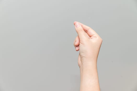 Human hand holding imaginary card on light gray background