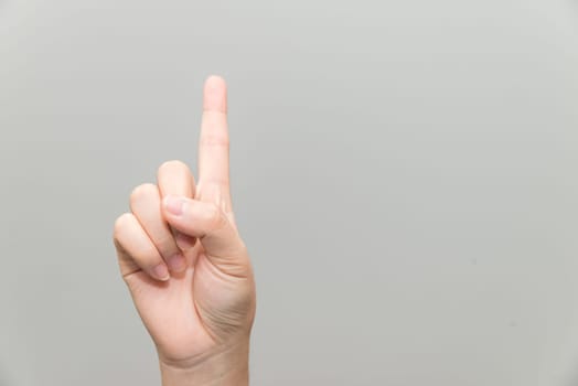 Human hand with one finger sticking up on light gray background