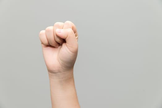 Human hand with closed fist on gray background