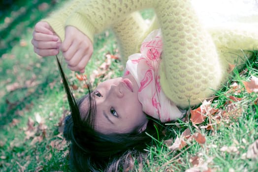 Beautiful young woman with skull covering head and face in sunshine