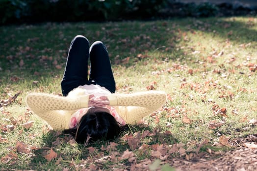 Beautiful young woman with skull covering head and face in sunshine