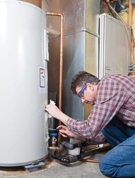 A plumber is performing maintenance on a residential water heater