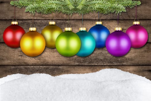 XMAS lettering in front of wooden wall and snow