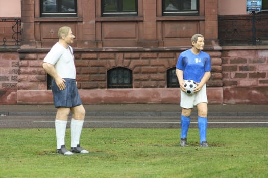 two life-size footballer figures,with ball