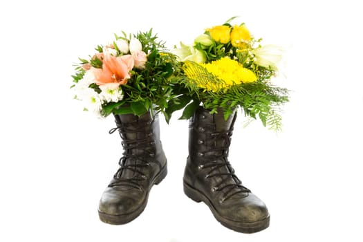 Two old boots with a bouquet of flowers