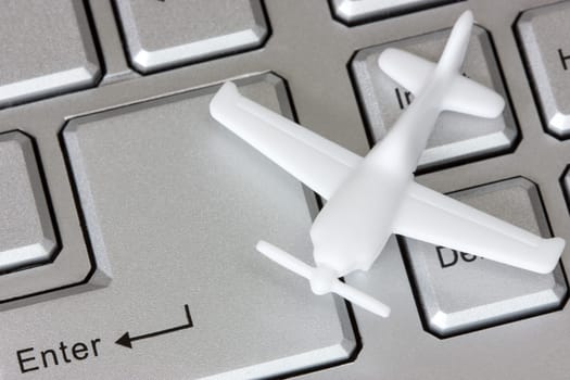 Plane on keyboard, to illustrate online booking or purchase of airline ticket