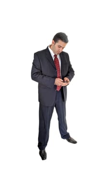 A tall handsome businessman standing for white background in a blue .suit dialling on his cell phone..