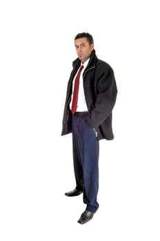 A tall and young businessman standing in a black coat for.white background with his hands in his pocket, looking serious..