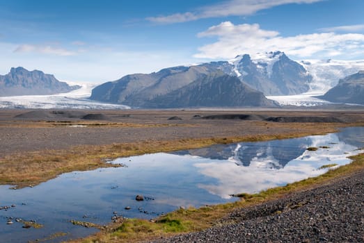 Glacier in Iceland reflected in a river