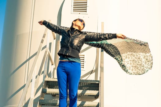 An image of girl holding canvas-cape and windturbine in background