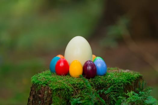 Colorful Easter eggs and a Nanduei on a tree stump