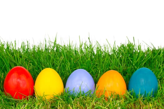 Colourful Easter eggs in a row on a meadow