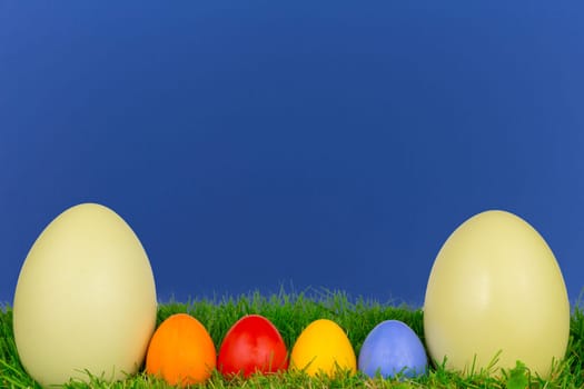 Colorful Easter eggs and a Nanduei in a meadow