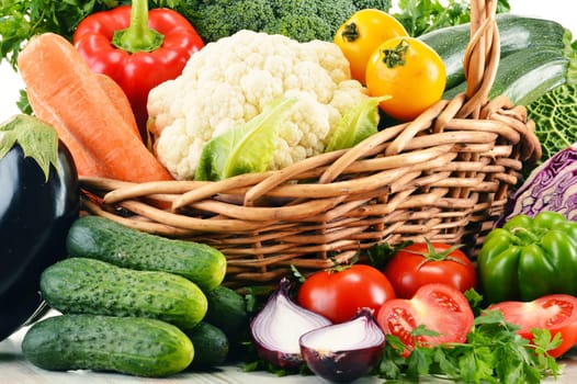 Composition with variety of fresh organic vegetables in wicker basket