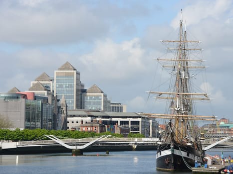 Modern buildings and tall ship in Dublin - Ireland.