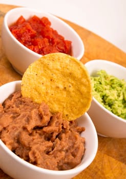 Food Appetizers Chips and Salsa Refried Beans Guacamole on Wood Cutting Board