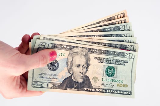 Woman holds out bills fanned out twenties and tens U.S. currency
