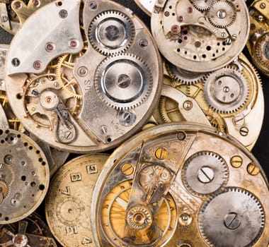 A pile of old pocket watches in various states