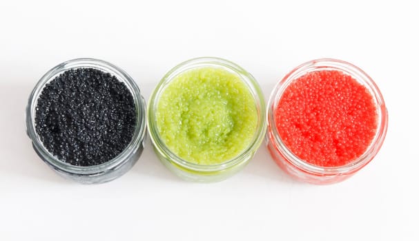 the red, green and black caviar in glass jars on withe background