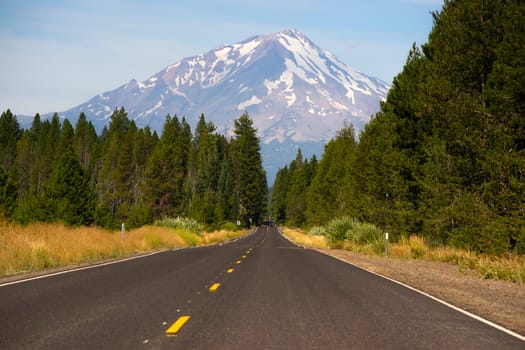 Two lane road heads west across California Mountain Landscape