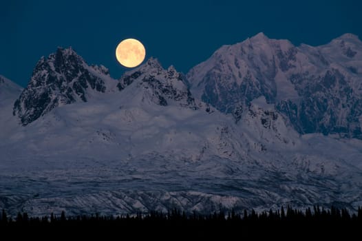 Moon rises over the land of the midnight sun
