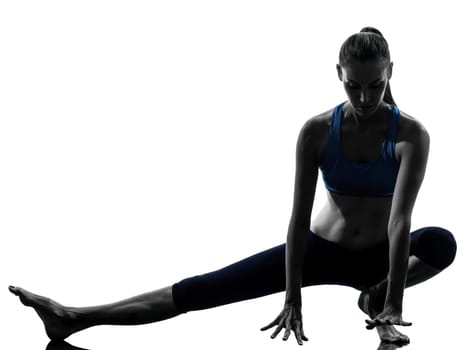 one caucasian woman exercising yoga stretching legs warm up in silhouette studio isolated on white background