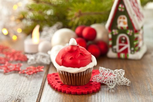 Small cupcake with Santa Claus cap made of frosting