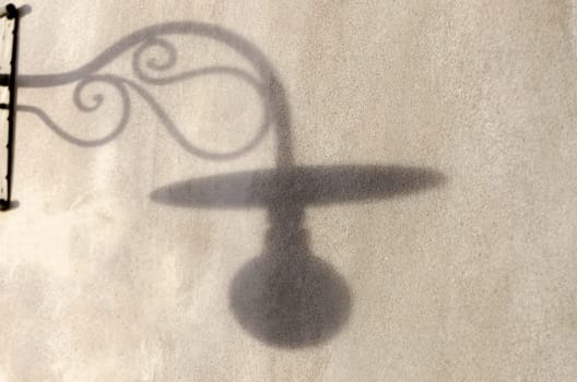 shadow of a lamppost on a wall at sunset