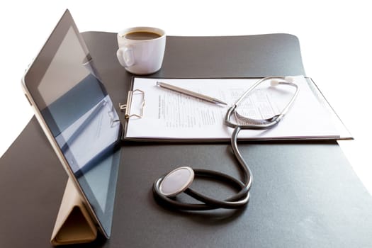 Medical record forms, stethoscope and Tablet PC on the desk