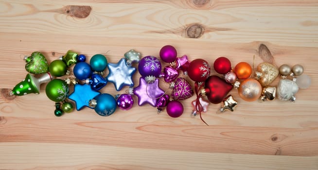 Colourful Christmas tree baubles on wooden background
