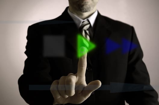 Business man pushing a green play button