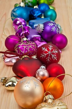 Colourful Christmas tree baubles on wooden background