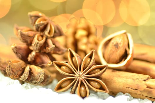 christmas season, cinnamon sticks, anise stars and nuts on bokeh background