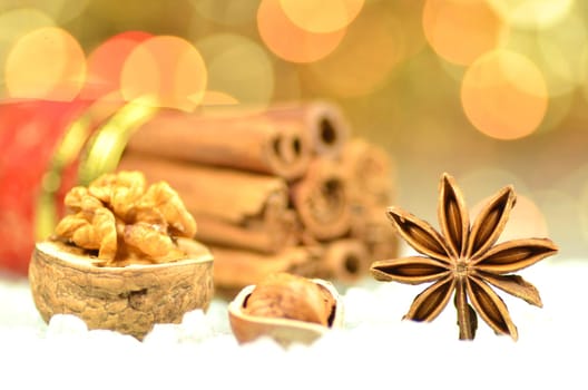 christmas season, cinnamon sticks, anise stars and nuts on bokeh background