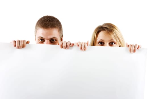 Young couple peeking out from behind the booth