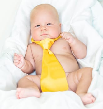Cute baby wearing yellow tie