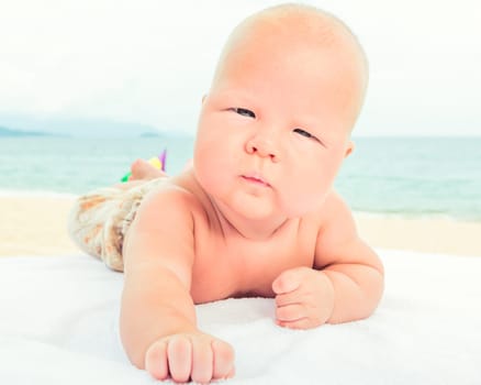 Cute baby laying on the sunbed at the beach