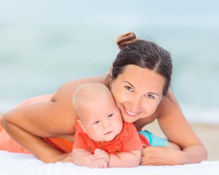 Baby and mom are relaxing on sunbed
