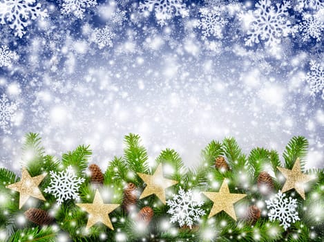 Studio shot of decorated fir branches on blue background with snowflakes