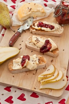 Caese,bread and fresh pears on cutting board
