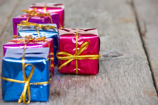 Row of glossy gifts on the wooden floor
