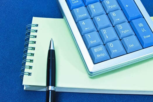 calculator and pen on blank notebook. Shot on background