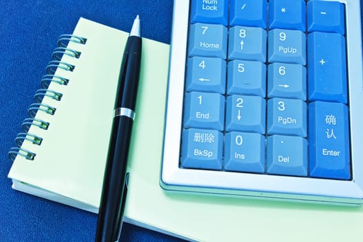 calculator and pen on blank notebook. Shot on background