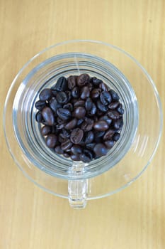 coffee beans in cup on the wood table