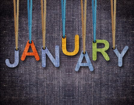 January letters hanging strings with blue sackcloth background.