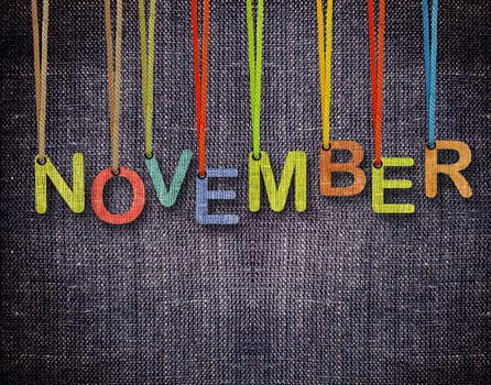November  letters hanging strings with blue sackcloth background.