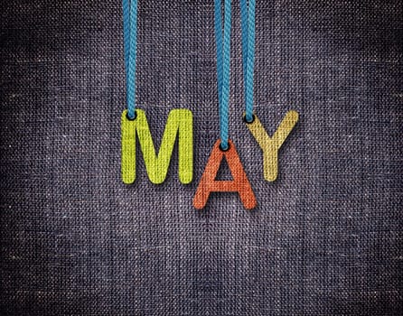 May letters hanging strings with blue sackcloth background.