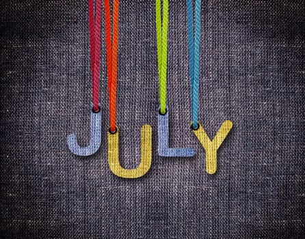 July letters hanging strings with blue sackcloth background.