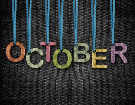 October letters hanging strings with blue sackcloth background.