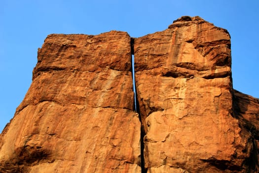 Huge rock surfaces soaked in morning sunlight with rich blue sky at Badami, Karnataka, India, Asia